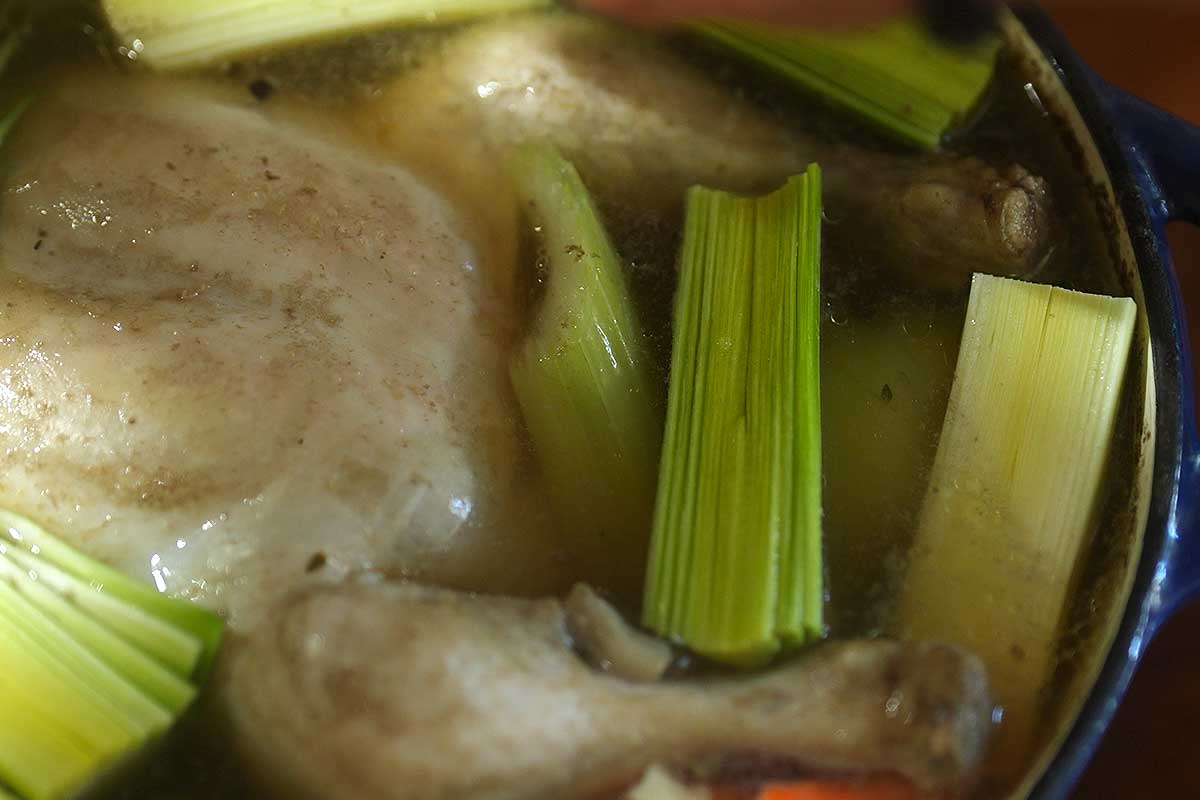 Leeks laid into the pot, cut side up, floating on the surface