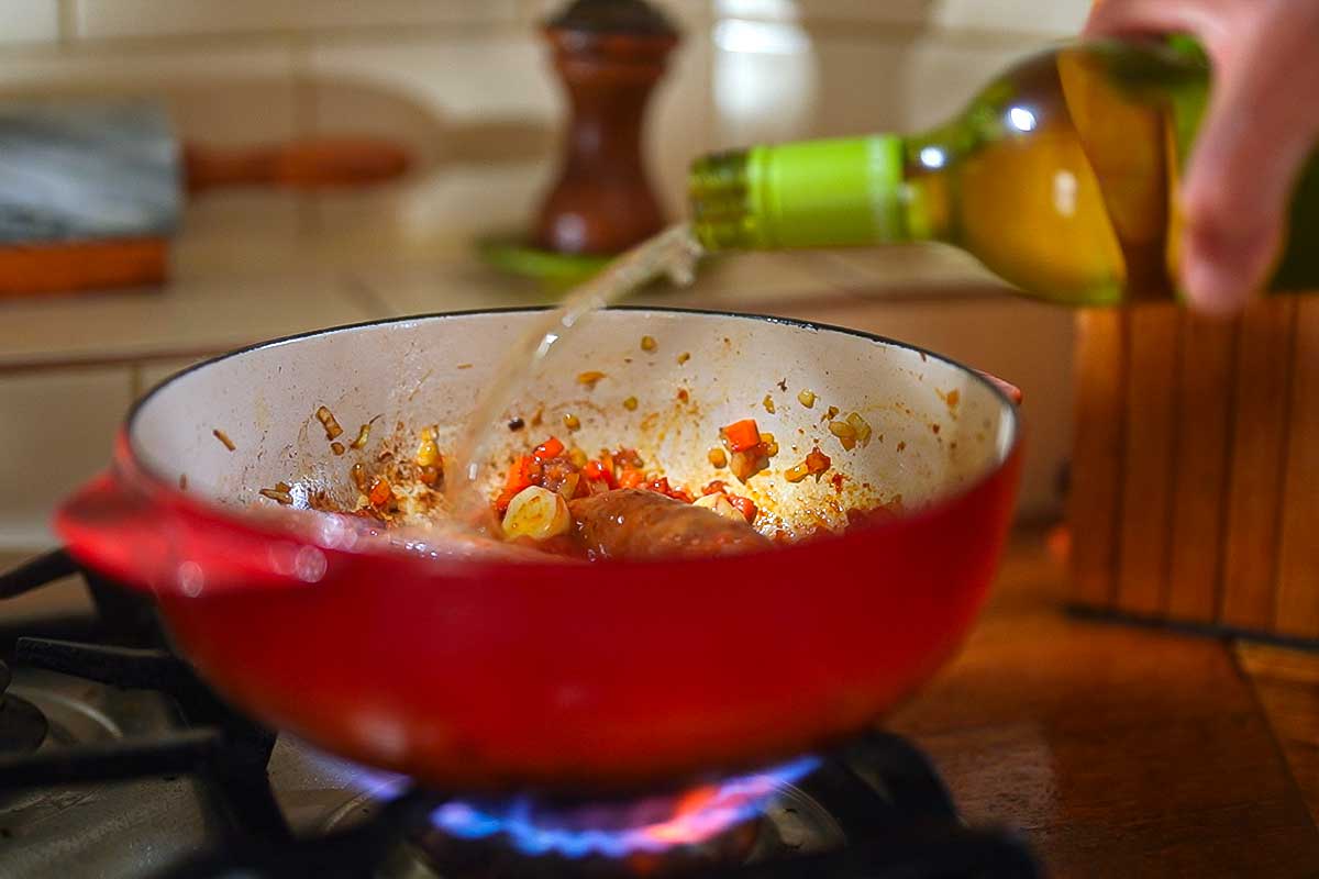 White wine poured into the pot, scraping up the browned bits from the base